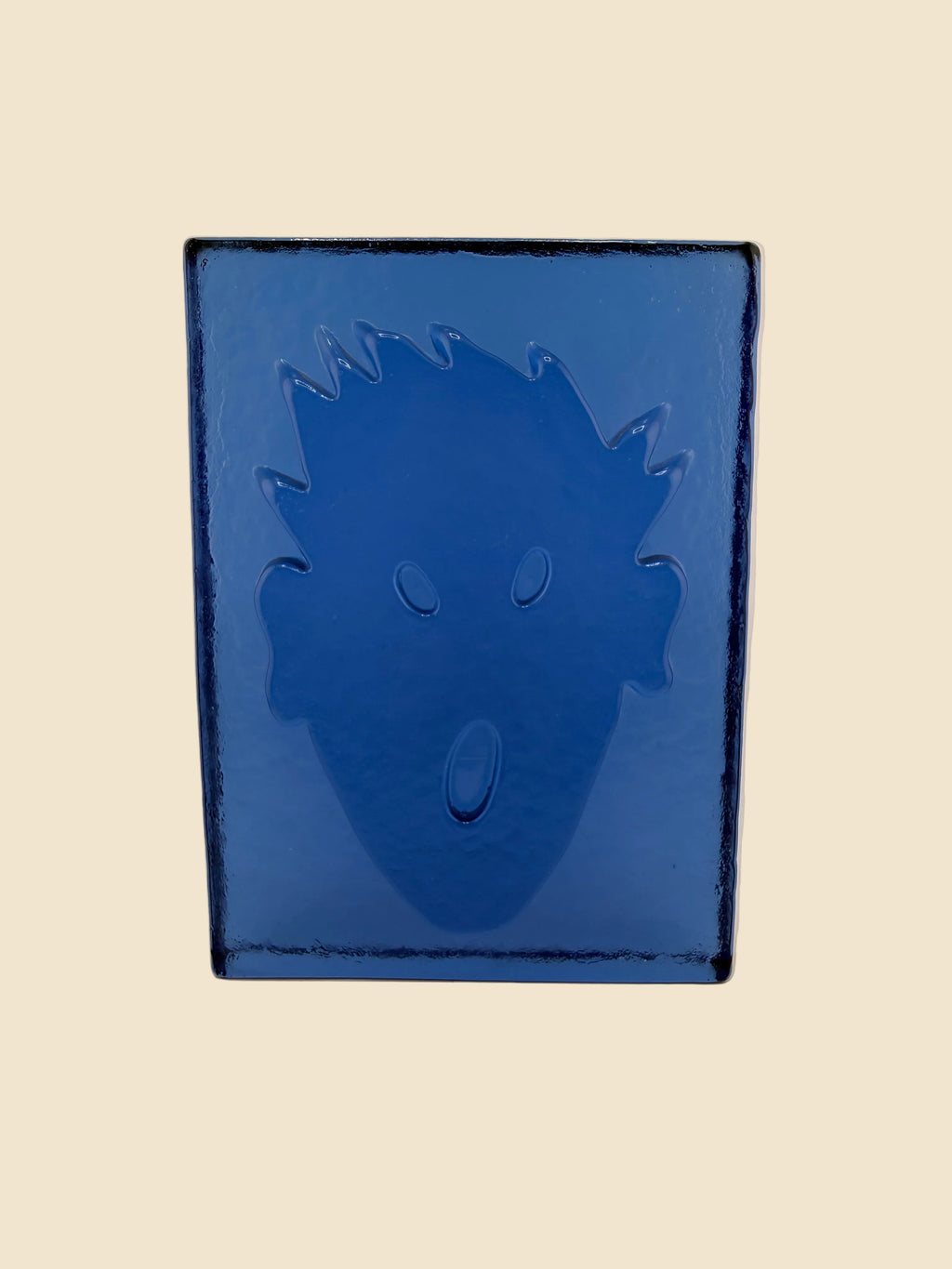 Rückseite der blauen Glasskulptur „Brick“ von Kiki Kogelnik mit reliefiertem Kopfmotiv