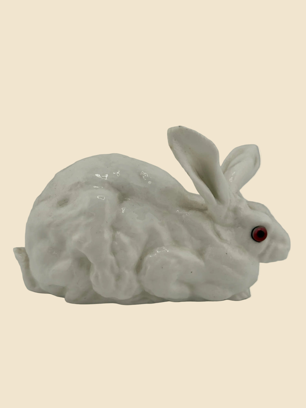 Kleine Porzellanfigur eines weißen Hasen mit roten Glasaugen